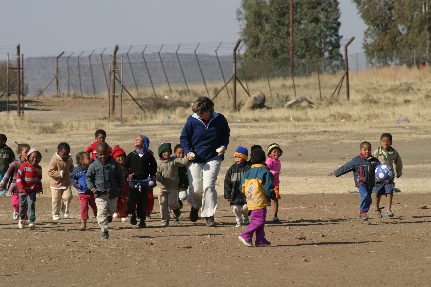 Preschoolers running with teacher