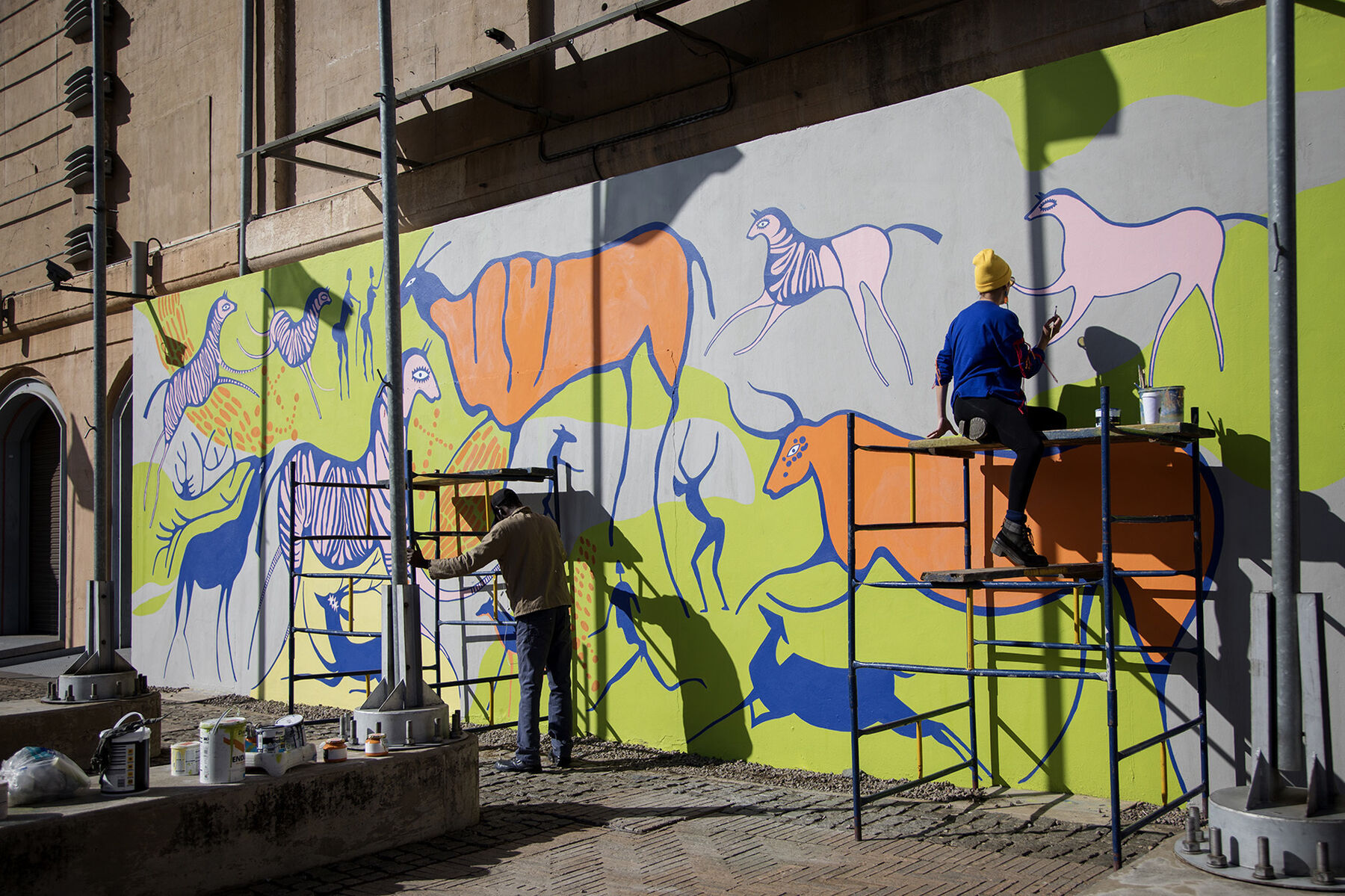 An Artist Paints A Rock Art Inspired Mural At Sci Bono